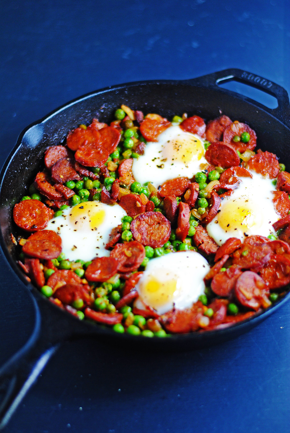 Baked eggs with peas, chorizo and bacon | white plate blank slate